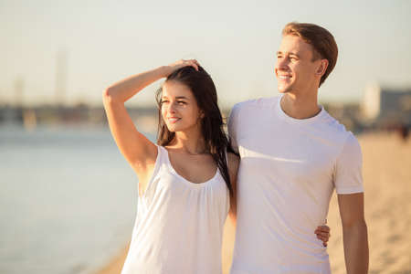 Loving young couple walk on the beach in summerの写真素材