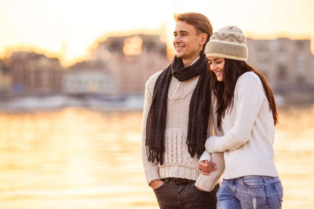 Loving young couple walk on the beach in autumnの写真素材