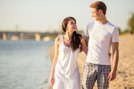 Loving young couple walk on the beach in summerの写真素材