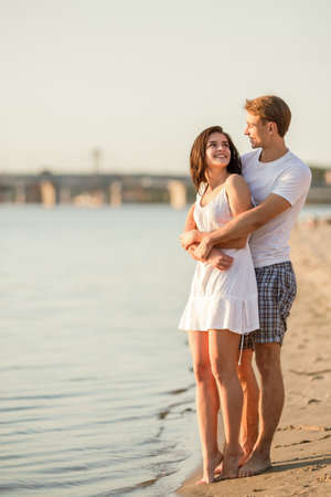Loving young couple walk on the beach in summerの写真素材