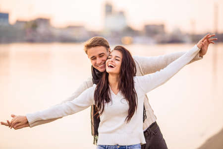 Loving young couple walk on the beach in autumnの写真素材