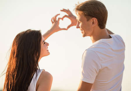 Loving young couple walk on the beach in summerの写真素材