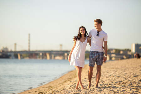 Loving young couple walk on the beach in summerの写真素材