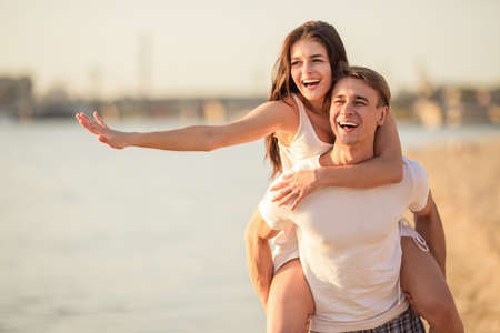 Loving young couple walk on the beach in summerの写真素材