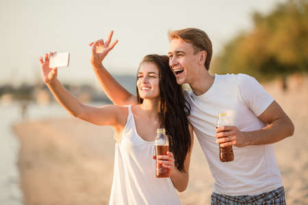 Loving young couple walk on the beach in summerの写真素材
