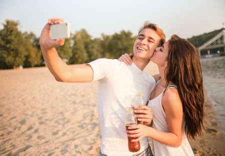 Loving young couple walk on the beach in summerの写真素材
