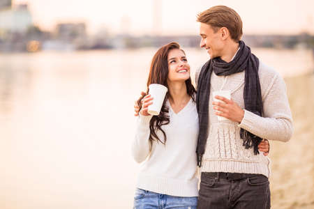 Loving young couple walk on the beach in autumnの写真素材