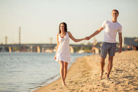 Loving young couple walk on the beach in summerの写真素材