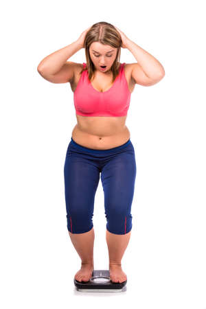 Fat woman diet measures the weight isolated on a white backgroundの写真素材