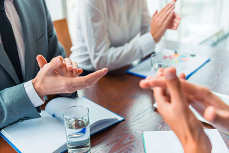 Group young business people sitting in office and holding meetingの写真素材
