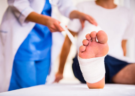 Injury leg. Young man with injured leg. Young woman doctor helps the patient