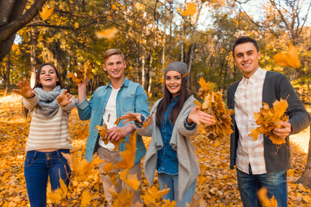 Group of young people students while walking autumn park