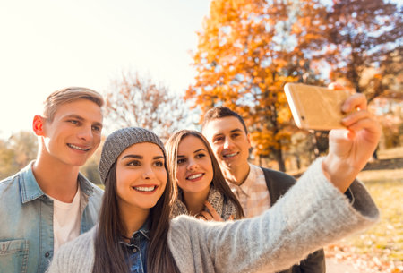 Group of young people students while walking autumn park