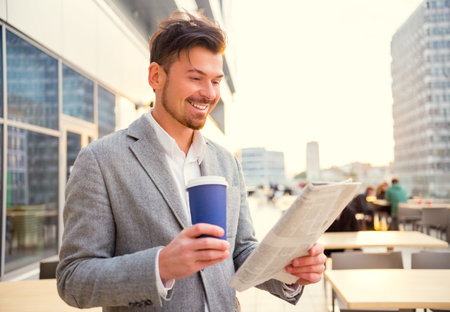Young successful businessman drinking coffee in the office centerの写真素材