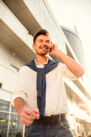Young successful businessman talking on the phone in the background office centerの写真素材