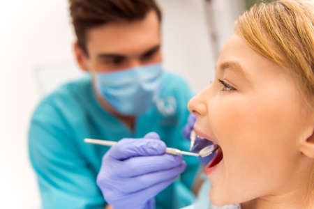 Dentist examine a little girl with an open mouth. Close-upの写真素材