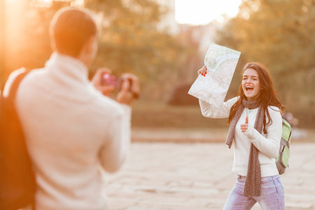 Young beautiful couple tourists use the camera during a walk in the city