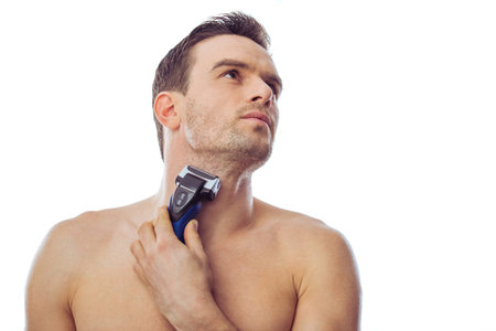 Portrait of handsome man using electric razor, isolated on a white background