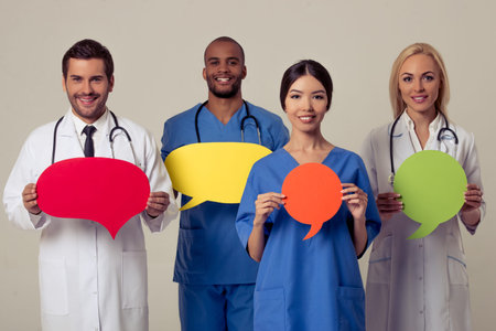 Group of medical doctors of different nationalities and genders is holding speech bubbles, looking...