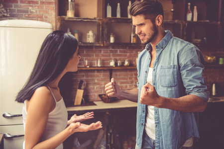 Young couple is having a quarrel in kitchen at homeの写真素材