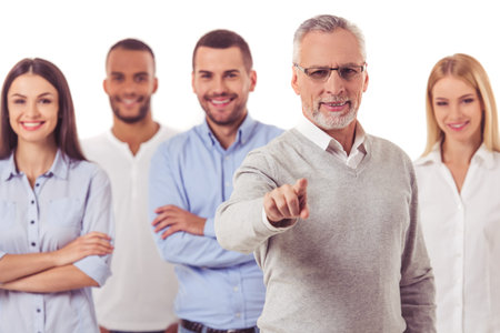 Beautiful business people in smart casual wear are looking at camera and smiling, isolated on white. Mature man is pointingの写真素材