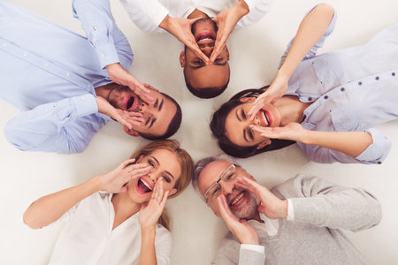 Top view of beautiful business people in smart casual wear calling, looking at camera and smiling,...