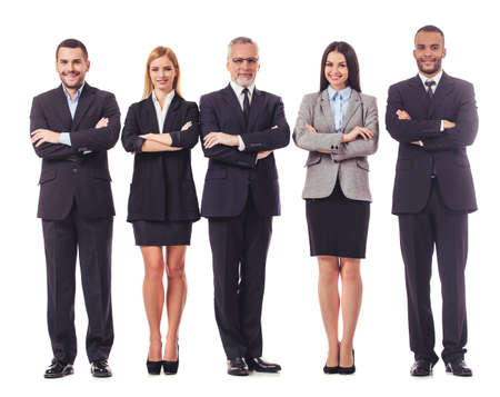 Full length portrait of beautiful business people in suits looking at camera and smiling while standing with folded arms on a white backgroundの写真素材