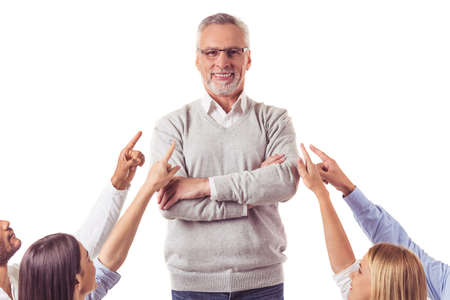 Handsome mature businessman in smart casual wear is standing with folded arms, looking at camera and smiling while hands are pointing at him, isolated on whiteの写真素材