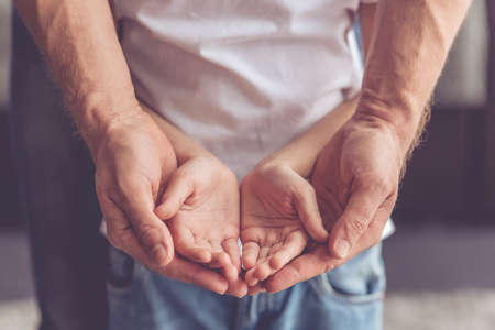 Cropped image of father and son keeping palms togetherの写真素材