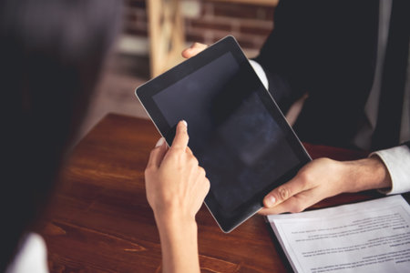 Cropped image of employer and employee during the job interview using a digital tablet