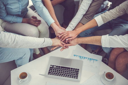 Cropped image of business team using putting hands together while working in office