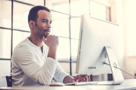 Afro American businessman is using a computer while working in office