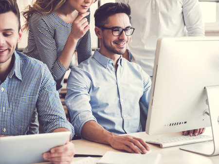 Beautiful business people are using computers and smiling while working in office