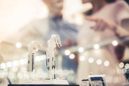 Beautiful couple is choosing jewelry in the shopping mall. Jewelry in focusの写真素材