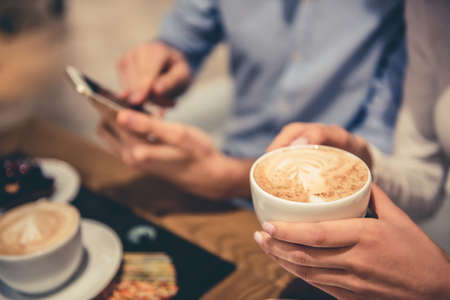 Cropped image of young couple drinking coffee while resting in the shopping mallの写真素材