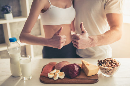 Cropped image of beautiful young sports couple cooking healthy food in kitchen at homeの写真素材