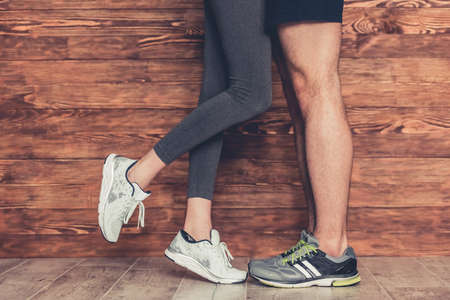 Cropped image of beautiful young sports couple on wooden backgroundの写真素材