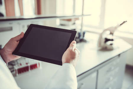 Cropped image of medical doctor using a digital tablet while working in laboratoryの写真素材