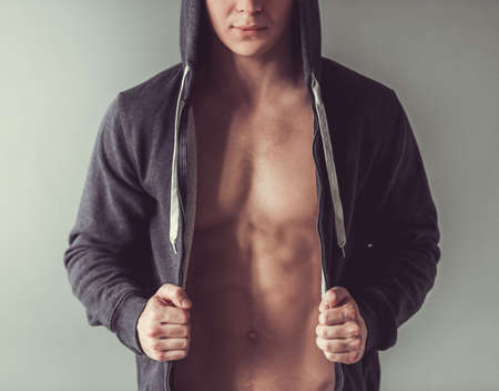 Cropped image of  handsome muscular sportsman, on gray backgroundの写真素材