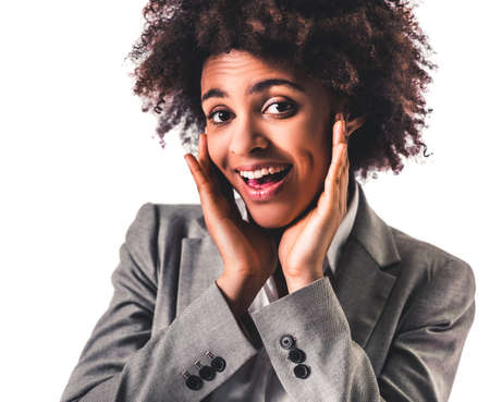 Beautiful young Afro American business woman in formal wear is showing excitement, isolated on whiteの写真素材
