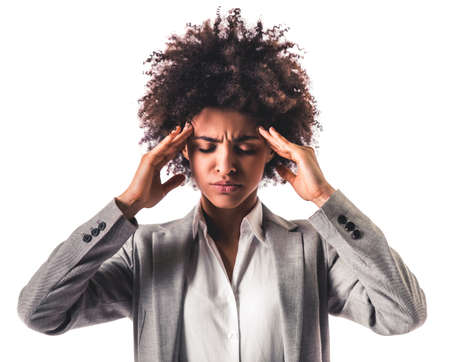 Beautiful young Afro American business woman in formal wear is having headache, isolated on whiteの写真素材
