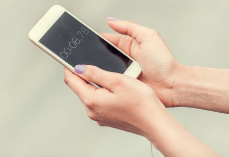 Cropped image of girl using timer on a smart phone for morning run