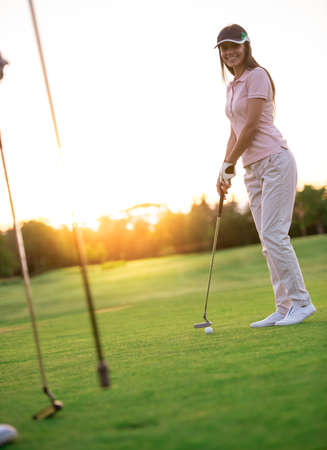 Beautiful young woman is smiling while playing golf together a mateの写真素材