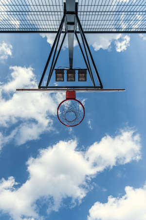 Bottom view of basketball hoop on blue sky backgroundの写真素材