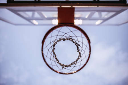 Bottom view of basketball hoop on evening sky backgroundの写真素材