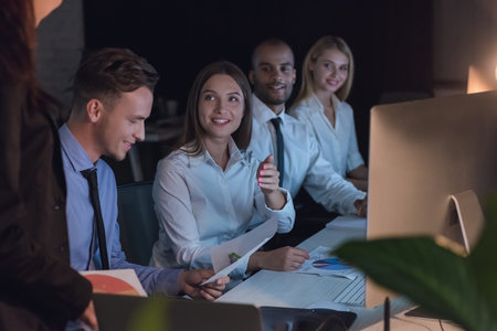 Successful business people are listening to their boss during the conference in office late at night