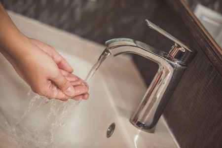 Cropped image of woman washing her hands in sinkの写真素材