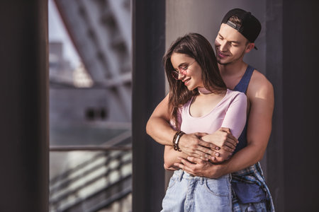 Stylish young couple is hugging while walking in the cityの写真素材