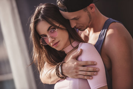 Stylish young couple is hugging while walking in the cityの写真素材