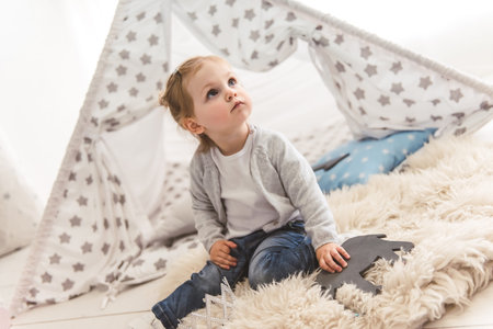 Cute little girl is playing in the children's roomの写真素材